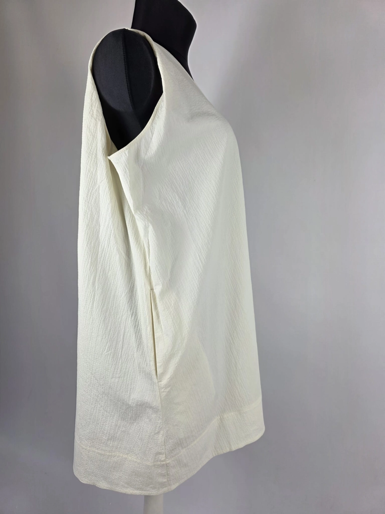 Kremowa sukienka oversize marki COS o gofrowanej strukturze, z dekoltem w serek i wiązaniem na plecach, idealna do minimalistycznych, letnich stylizacji premium