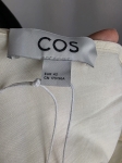 Kremowa sukienka oversize marki COS o gofrowanej strukturze, z dekoltem w serek i wiązaniem na plecach, idealna do minimalistycznych, letnich stylizacji premium