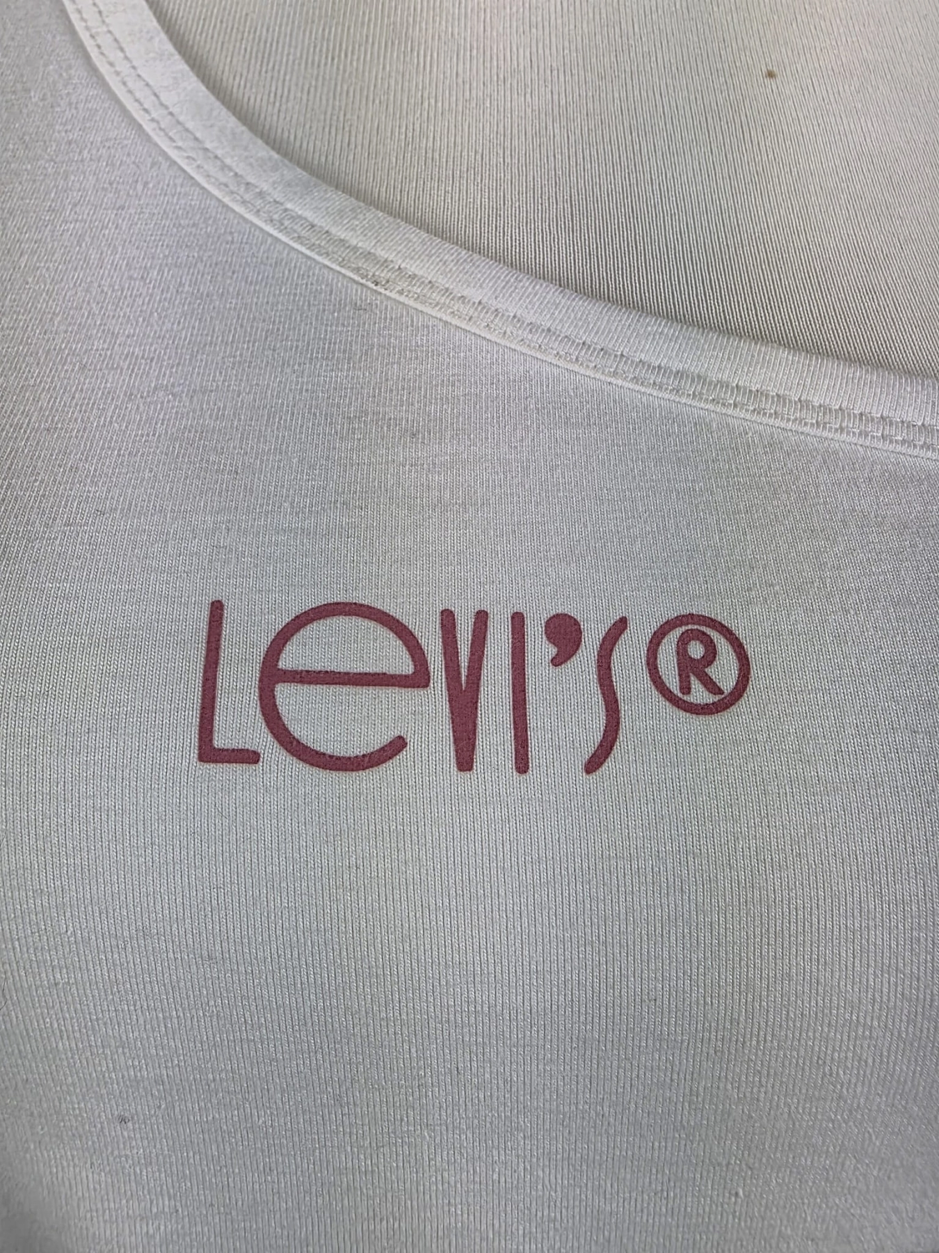 Oryginalny asymetryczny top damski Levi's w rozmiarze M, wykonany z prążkowanej bawełny w kolorze białym z subtelnym logo na piersi