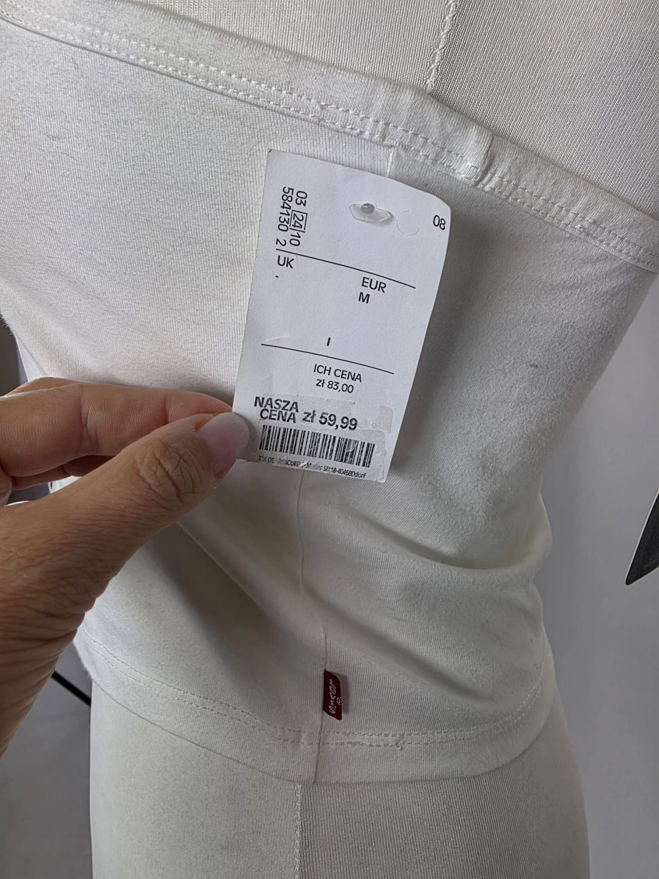Oryginalny asymetryczny top damski Levi's w rozmiarze M, wykonany z prążkowanej bawełny w kolorze białym z subtelnym logo na piersi