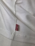 Oryginalny asymetryczny top damski Levi's w rozmiarze M, wykonany z prążkowanej bawełny w kolorze białym z subtelnym logo na piersi
