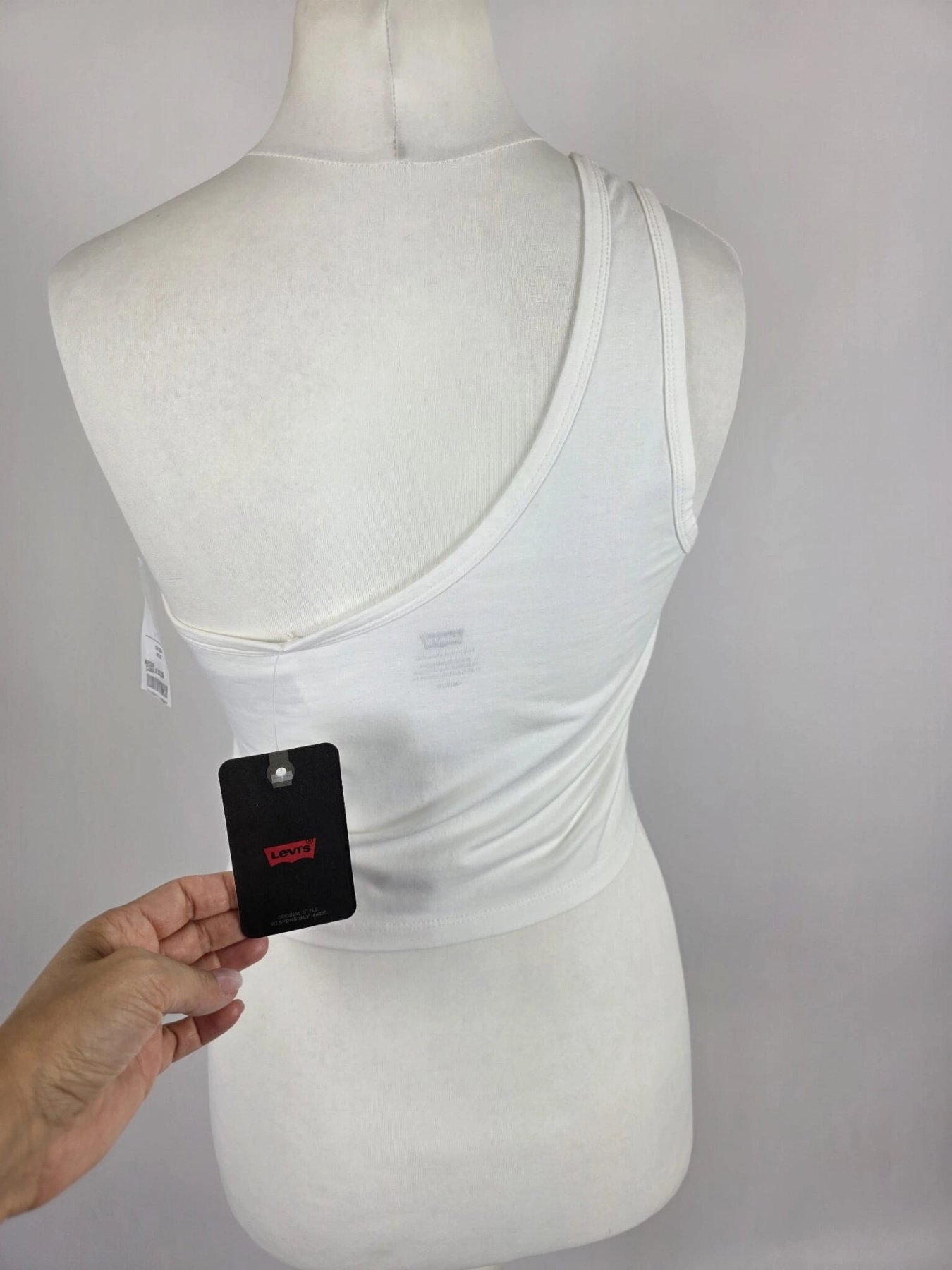 Oryginalny asymetryczny top damski Levi's w rozmiarze M, wykonany z prążkowanej bawełny w kolorze białym z subtelnym logo na piersi