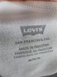 Oryginalny asymetryczny top damski Levi's w rozmiarze M, wykonany z prążkowanej bawełny w kolorze białym z subtelnym logo na piersi
