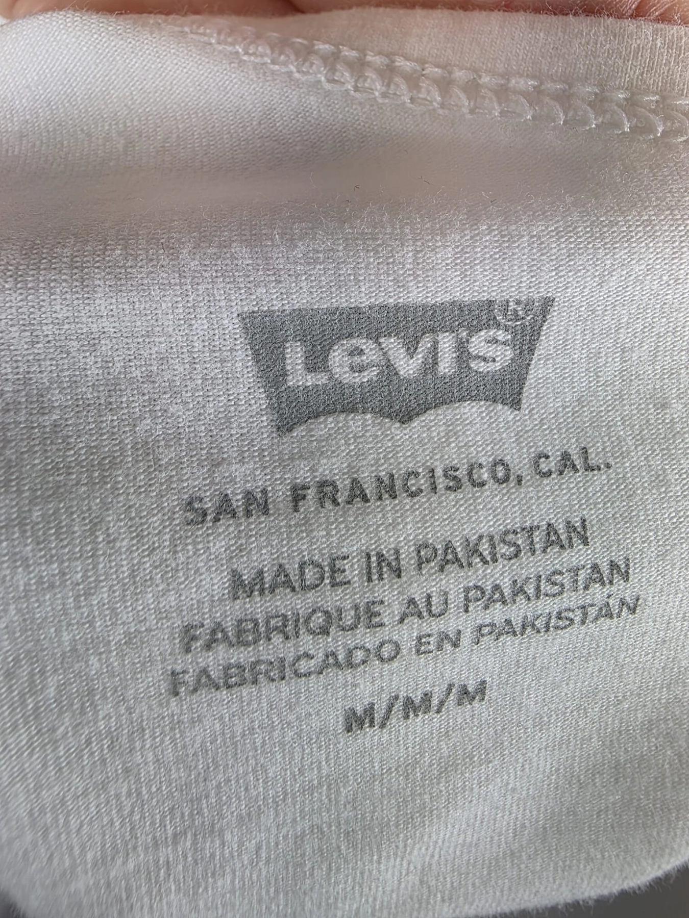 Oryginalny asymetryczny top damski Levi's w rozmiarze M, wykonany z prążkowanej bawełny w kolorze białym z subtelnym logo na piersi