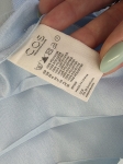 Ekskluzywny komplet premium składający się z granatowego polo Helly Hansen i błękitnej, plisowanej spódnicy midi marki COS to idealna, kobieca stylizacja na każdą okazję