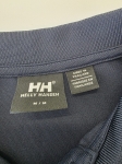 Ekskluzywny komplet premium składający się z granatowego polo Helly Hansen i błękitnej, plisowanej spódnicy midi marki COS to idealna, kobieca stylizacja na każdą okazję