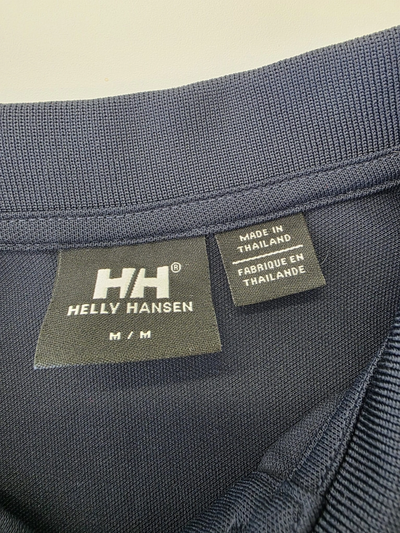 Ekskluzywny komplet premium składający się z granatowego polo Helly Hansen i błękitnej, plisowanej spódnicy midi marki COS to idealna, kobieca stylizacja na każdą okazję