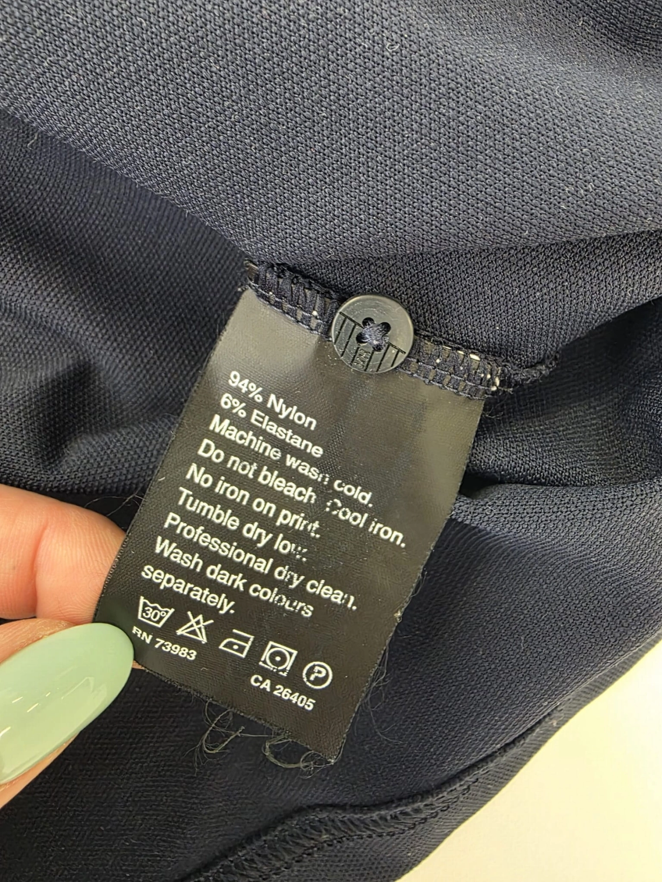 Ekskluzywny komplet premium składający się z granatowego polo Helly Hansen i błękitnej, plisowanej spódnicy midi marki COS to idealna, kobieca stylizacja na każdą okazję