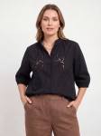 Czarna, bawełniana bluzka plus size marki xlnt z haftem angielskim i elegancką stójką to stylowy oraz niezwykle wygodny wybór, który doskonale uzupełni każdą kobiecą stylizację premium