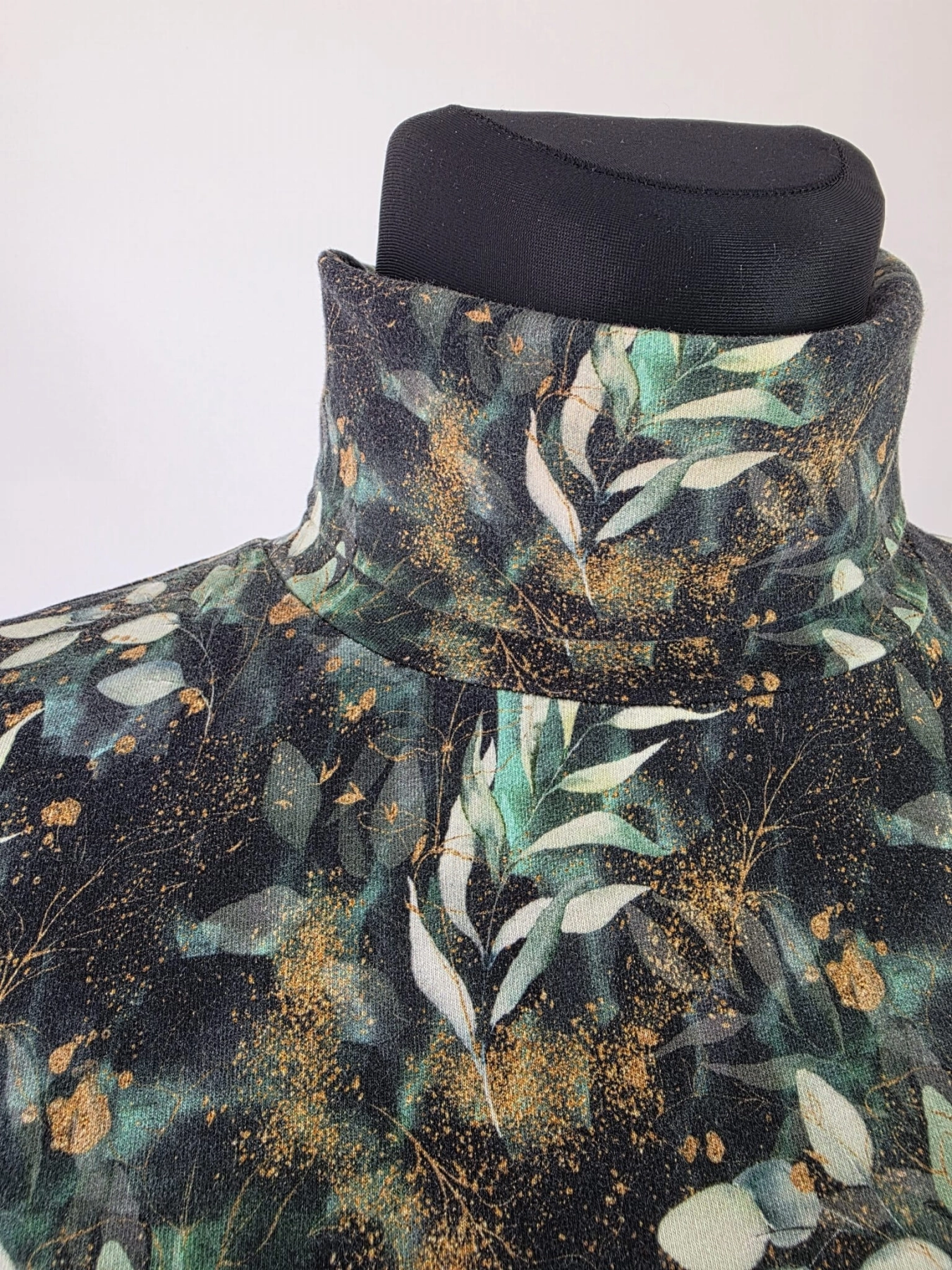 Ręcznie szyty damski golf w ciemnozielony botanical print ze złotymi detalami to elegancka i wygodna propozycja dopasowana do każdej kobiecej sylwetki