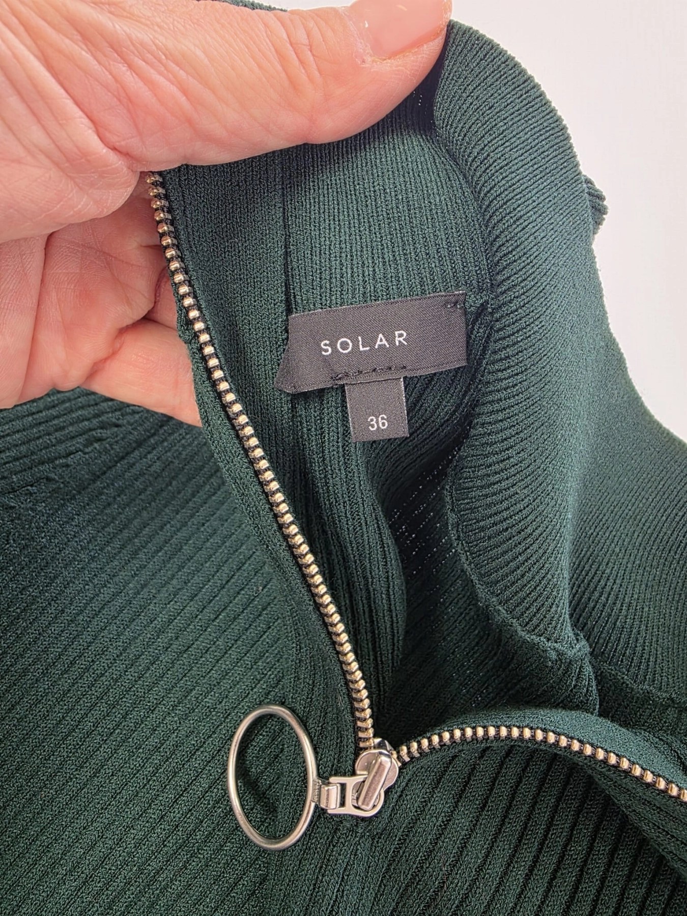 Dopasowana, dzianinowa sukienka midi marki Solar w kolorze butelkowej zieleni z prążkowanym splotem, rozcięciem i ozdobnym zamkiem przy dekolcie