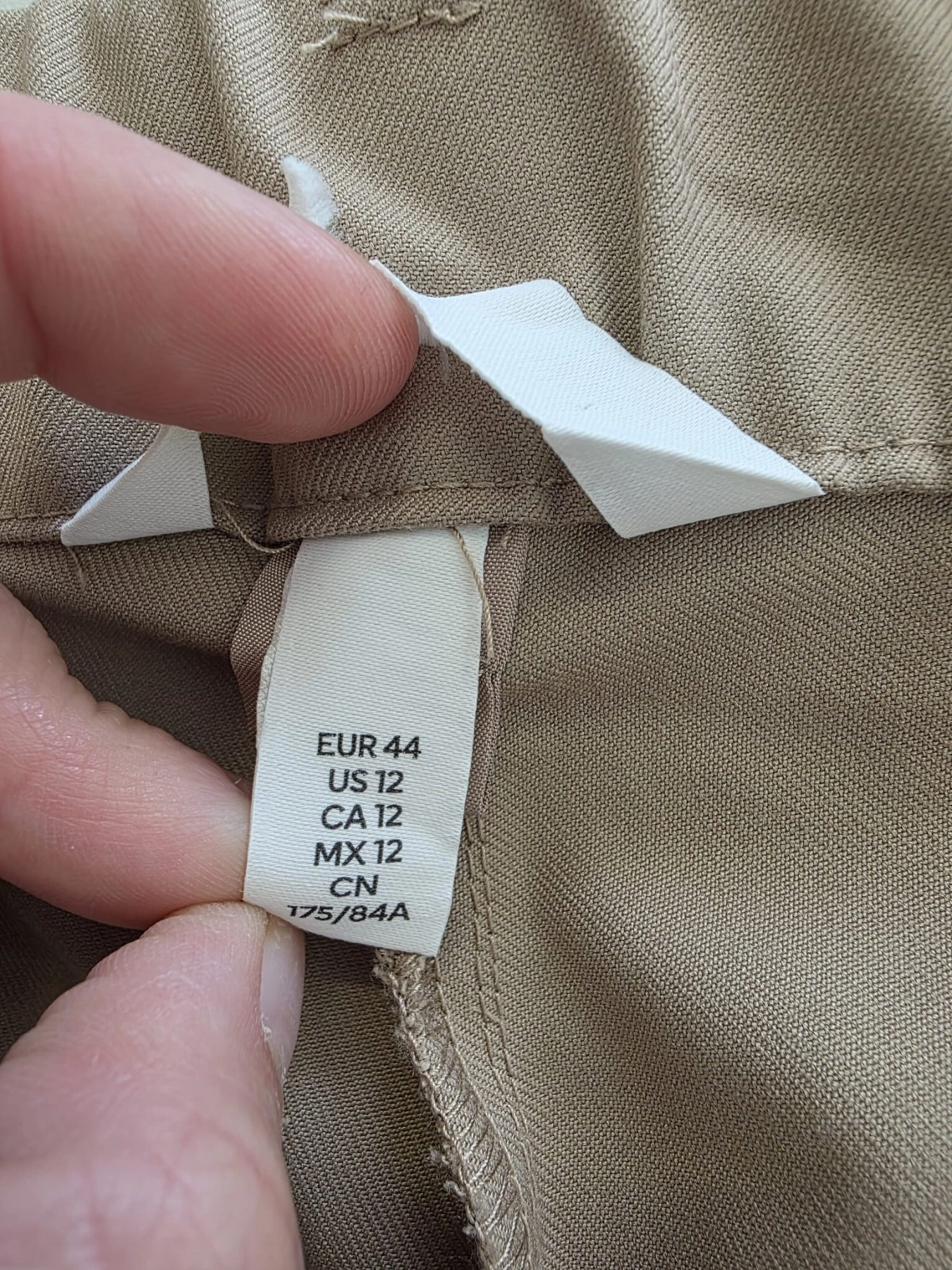 Dwuczęściowa kobieca stylizacja premium składająca się z wiskozowej bluzki polo ZHANDA w pionowe pasy oraz beżowych spodni HM z wysokim stanem