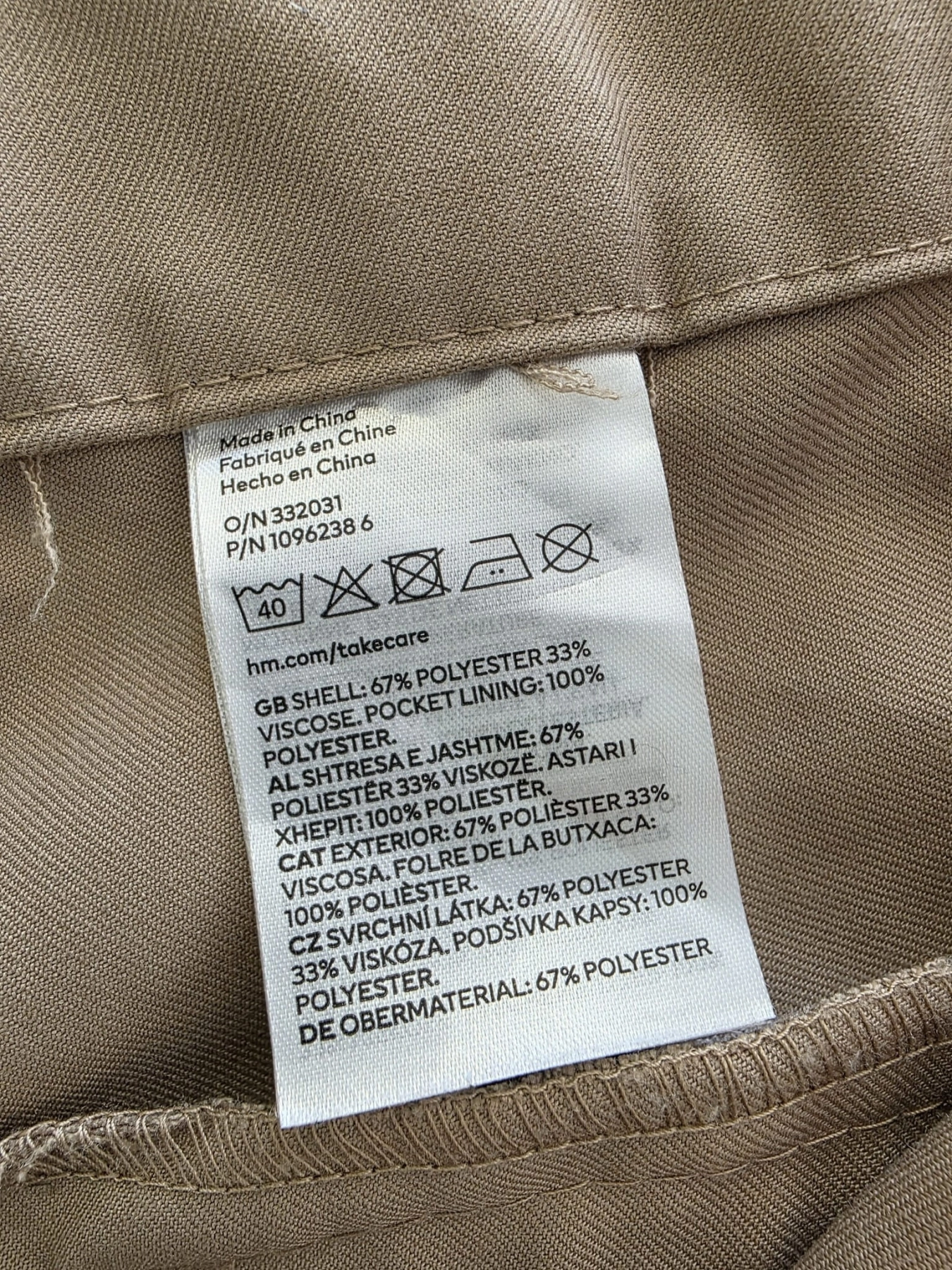 Dwuczęściowa kobieca stylizacja premium składająca się z wiskozowej bluzki polo ZHANDA w pionowe pasy oraz beżowych spodni HM z wysokim stanem