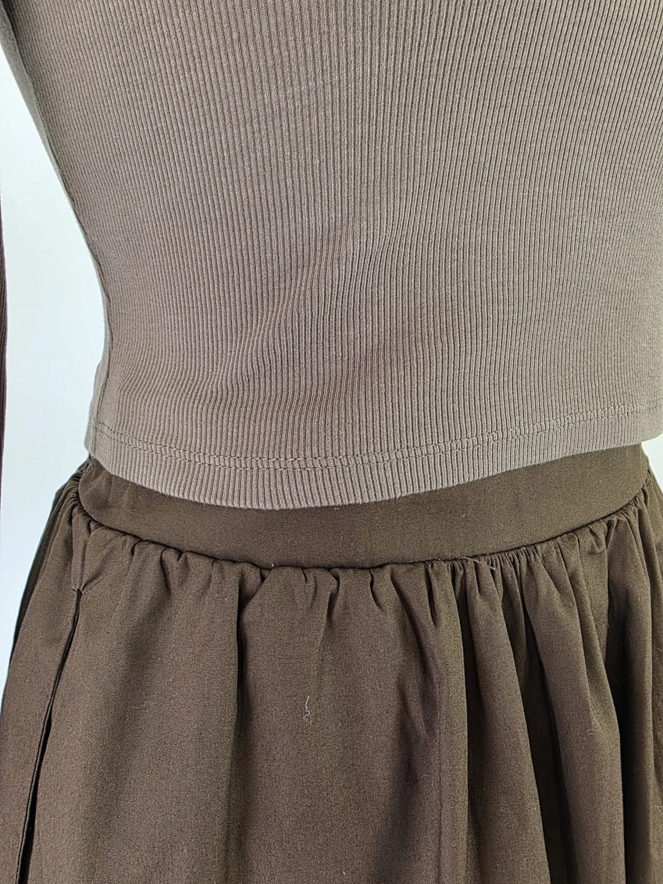 Czekoladowa stylizacja damska z dopasowaną bluzką JJXX, bawełnianą spódnicą Threadbare oraz wełnianym narzutem fransa gwarantuje elegancki wygląd i pełen komfort noszenia
