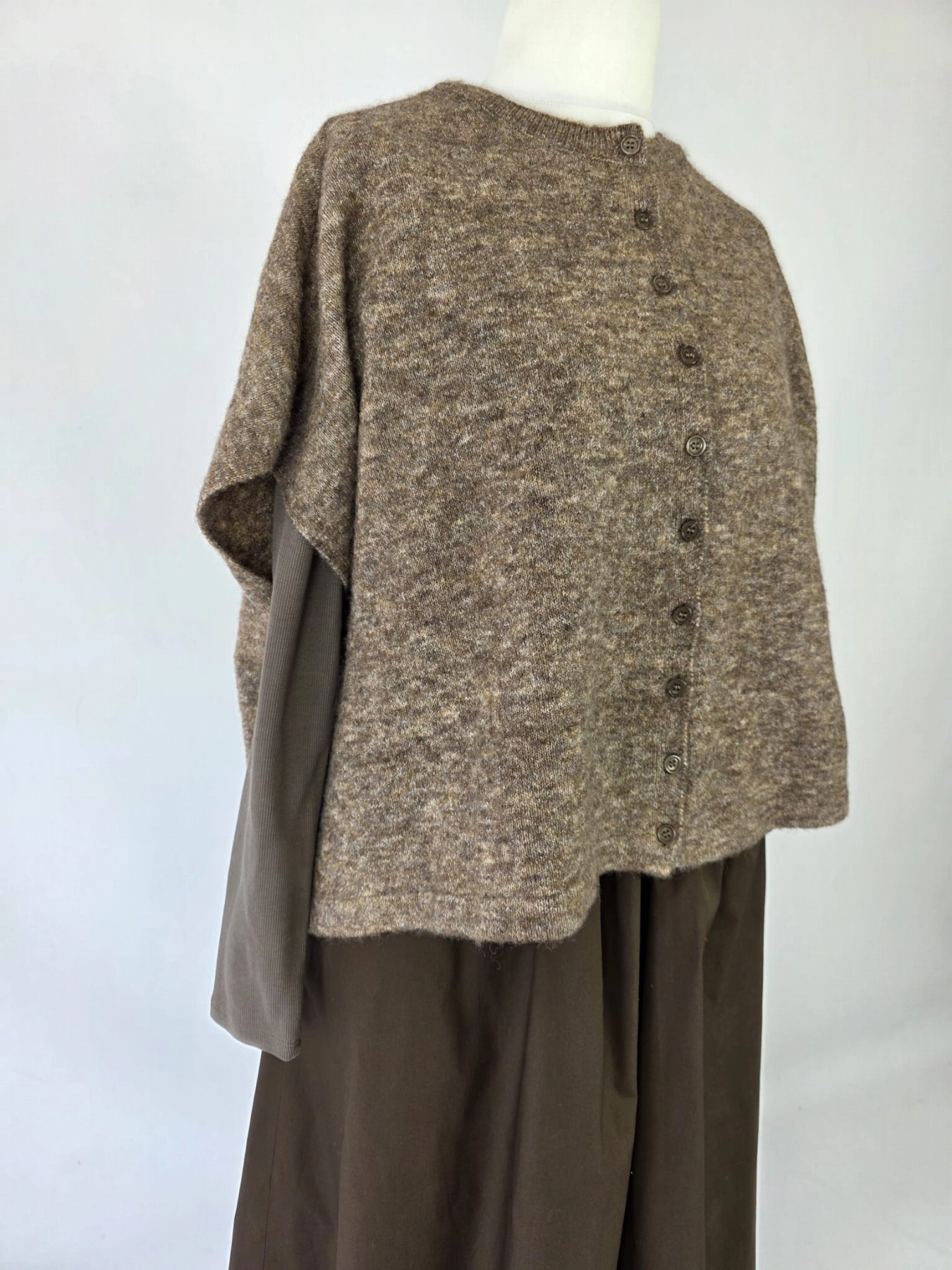Czekoladowa stylizacja damska z dopasowaną bluzką JJXX, bawełnianą spódnicą Threadbare oraz wełnianym narzutem fransa gwarantuje elegancki wygląd i pełen komfort noszenia