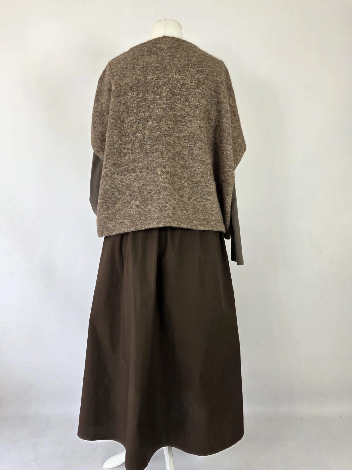 Czekoladowa stylizacja damska z dopasowaną bluzką JJXX, bawełnianą spódnicą Threadbare oraz wełnianym narzutem fransa gwarantuje elegancki wygląd i pełen komfort noszenia