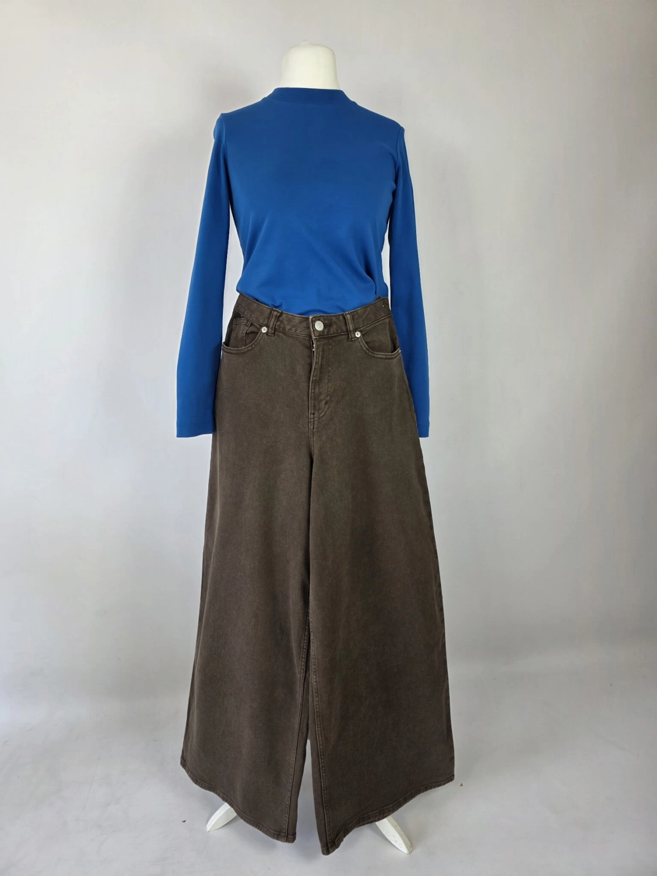 Stylowy zestaw kobiecy z niebieską bluzką COS, lnianą narzutką Zara, brązowymi spodniami wide leg Monki oraz paskiem