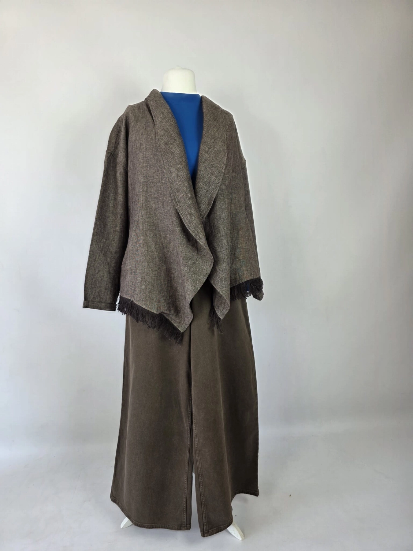 Stylowy zestaw kobiecy z niebieską bluzką COS, lnianą narzutką Zara, brązowymi spodniami wide leg Monki oraz paskiem