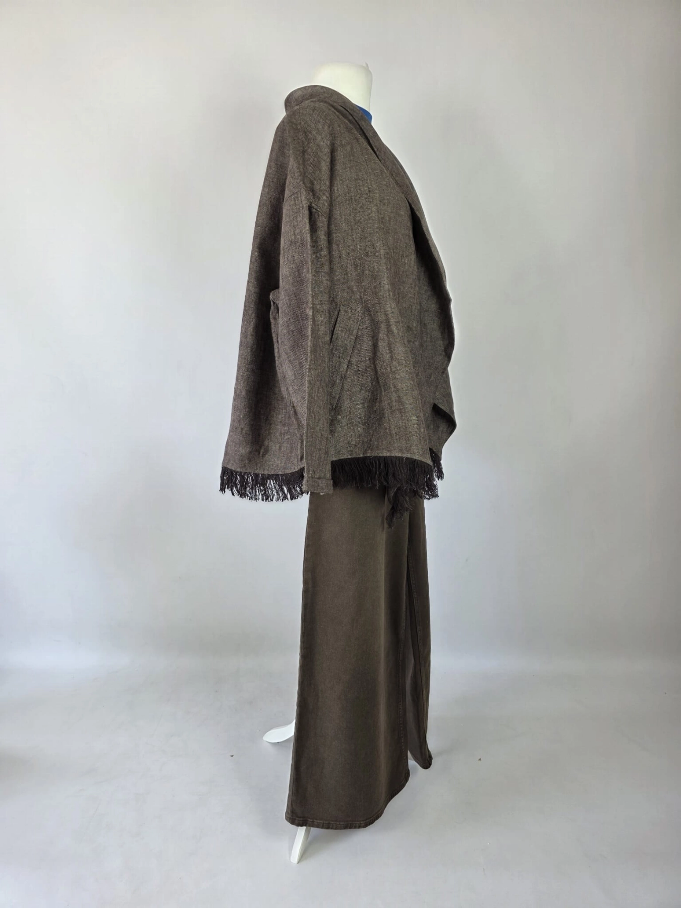 Stylowy zestaw kobiecy z niebieską bluzką COS, lnianą narzutką Zara, brązowymi spodniami wide leg Monki oraz paskiem