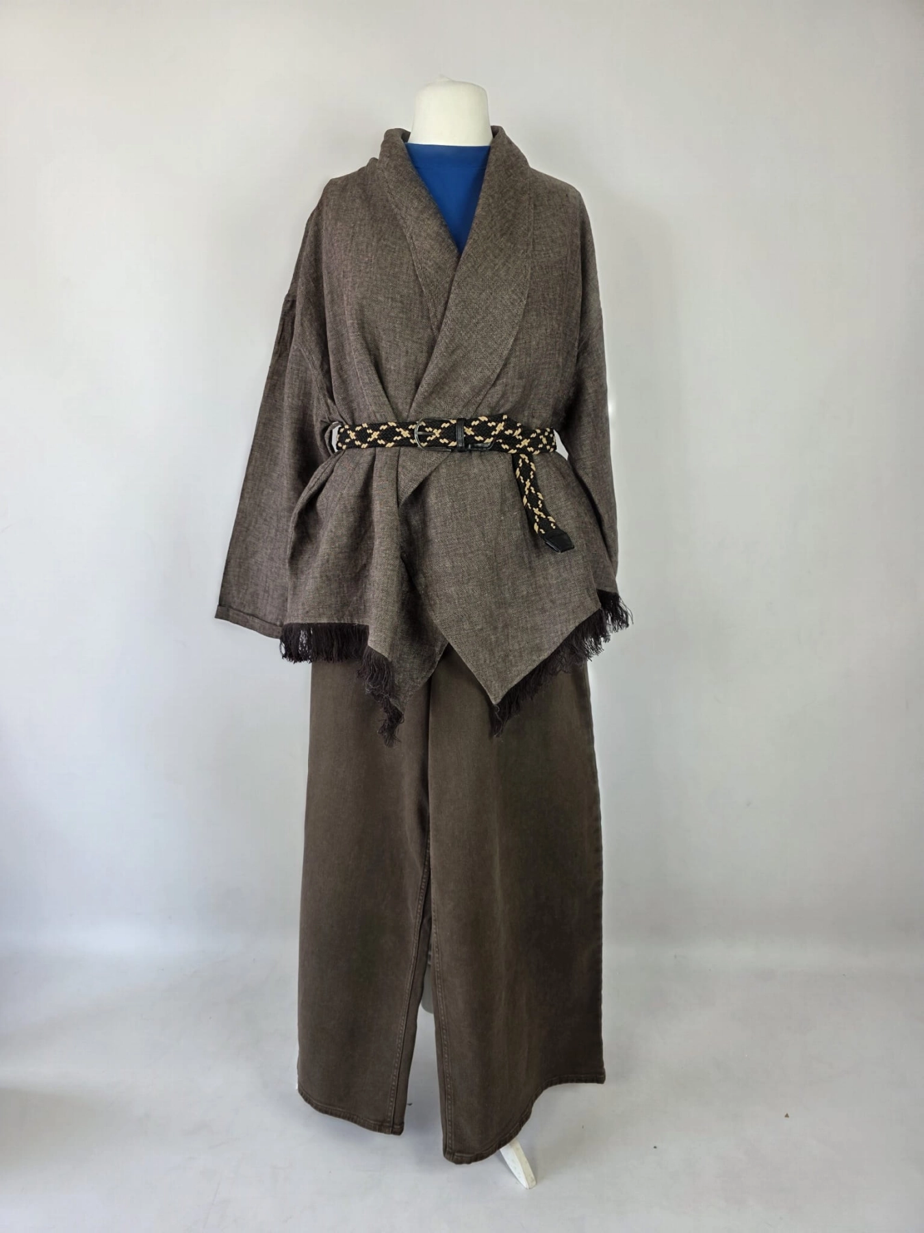 Stylowy zestaw kobiecy z niebieską bluzką COS, lnianą narzutką Zara, brązowymi spodniami wide leg Monki oraz paskiem