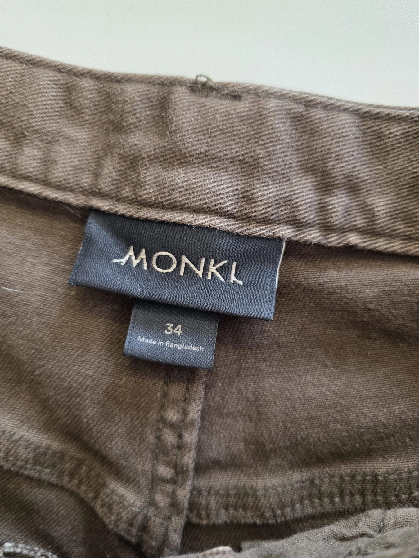 Stylowy zestaw kobiecy z niebieską bluzką COS, lnianą narzutką Zara, brązowymi spodniami wide leg Monki oraz paskiem