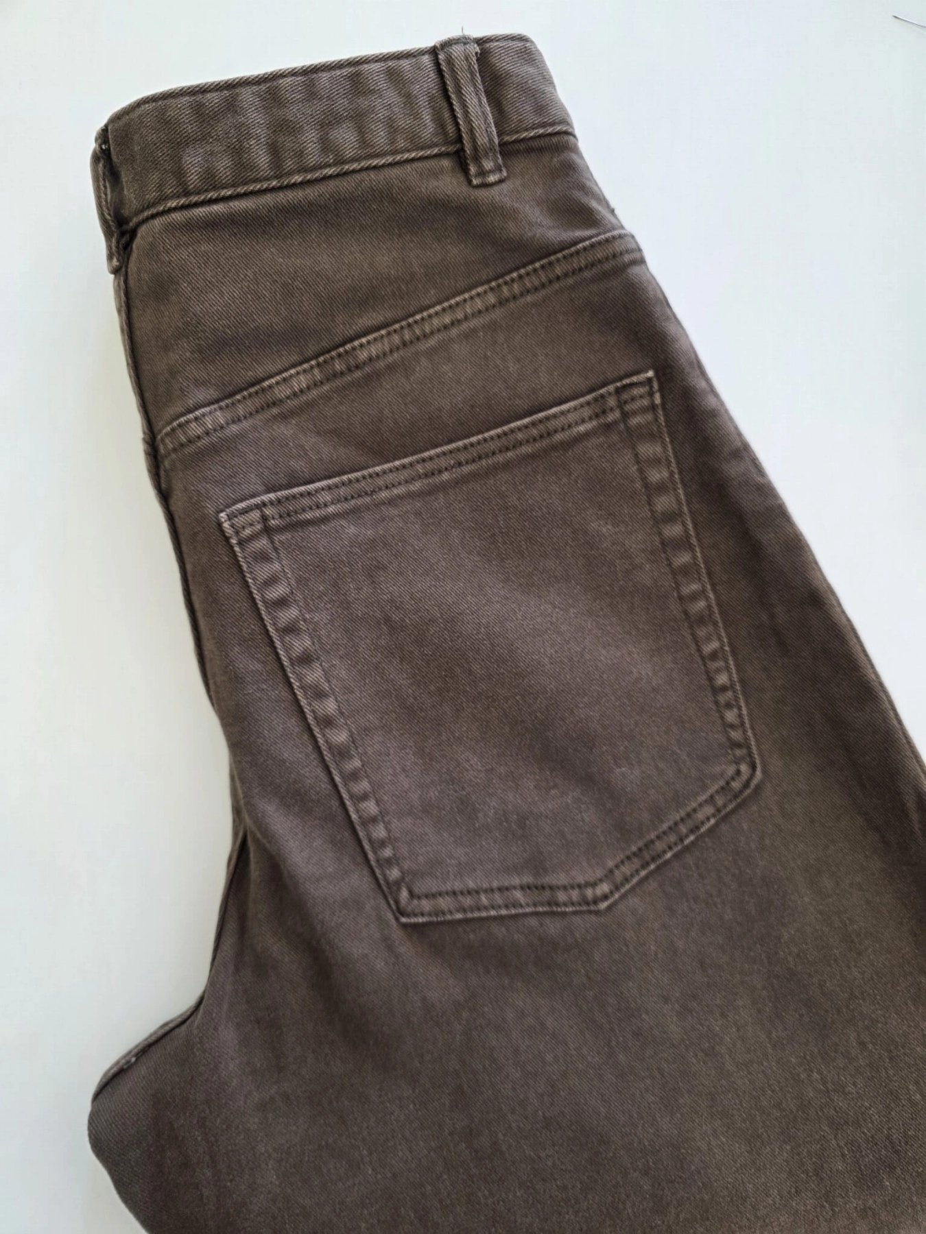 Stylowy zestaw kobiecy z niebieską bluzką COS, lnianą narzutką Zara, brązowymi spodniami wide leg Monki oraz paskiem