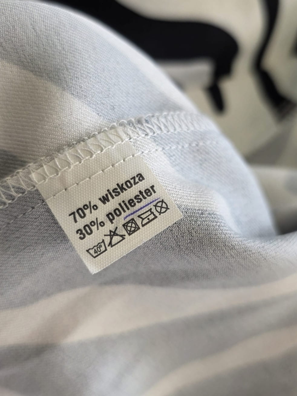 Stylowy zestaw kobiecy składający się z zielonej marynarki Zara, wzorzystej koszuli Andżela oraz czarnych jeansów Karve z wysokim stanem
