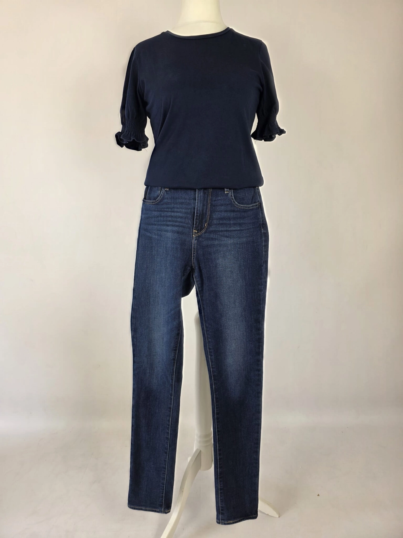 Damski komplet ze stylizacją premium: beżowa katana mbyM, granatowa bluzka Mellowfield oraz jeansy z wysokim stanem Levi's 721 High Rise Skinny