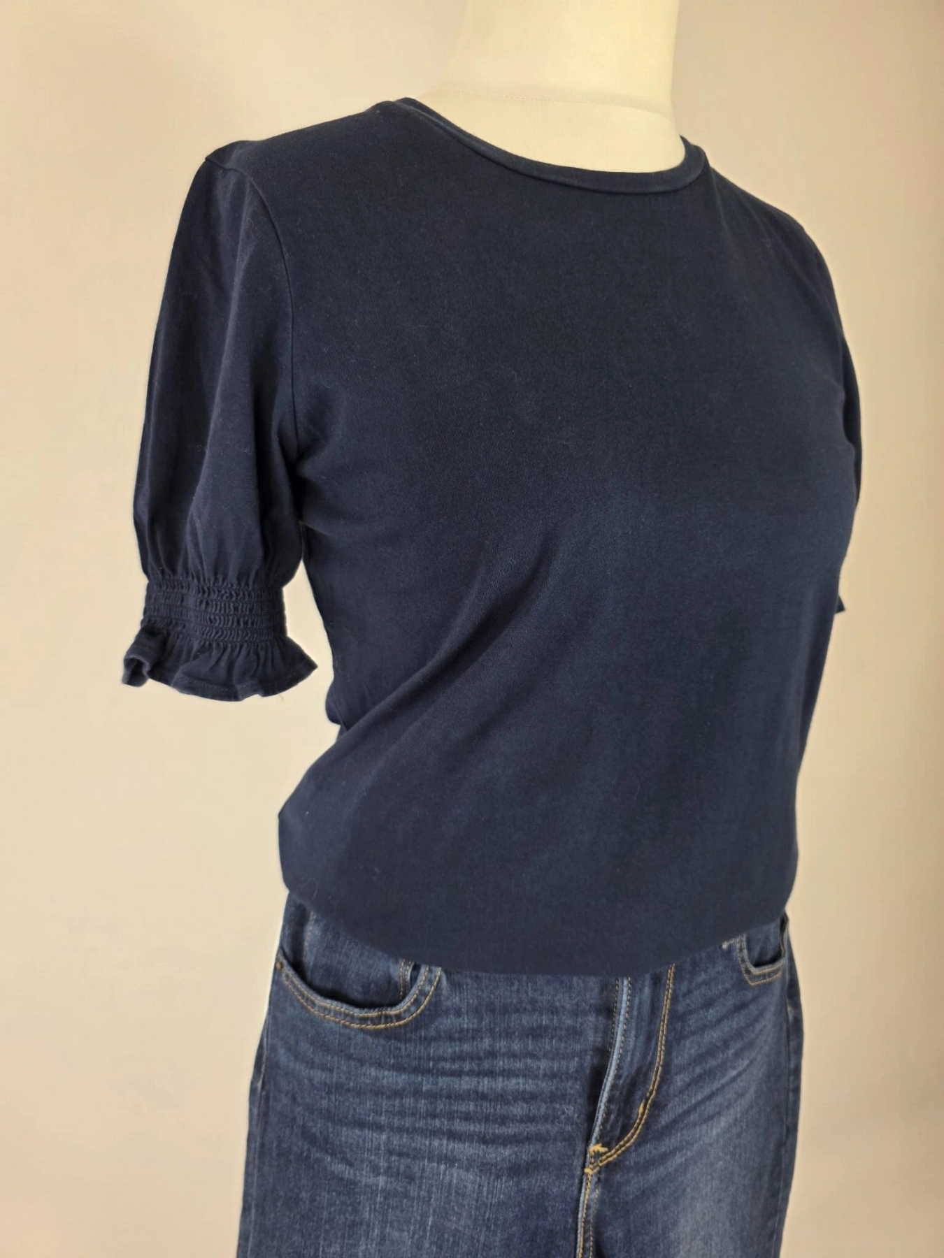 Damski komplet ze stylizacją premium: beżowa katana mbyM, granatowa bluzka Mellowfield oraz jeansy z wysokim stanem Levi's 721 High Rise Skinny