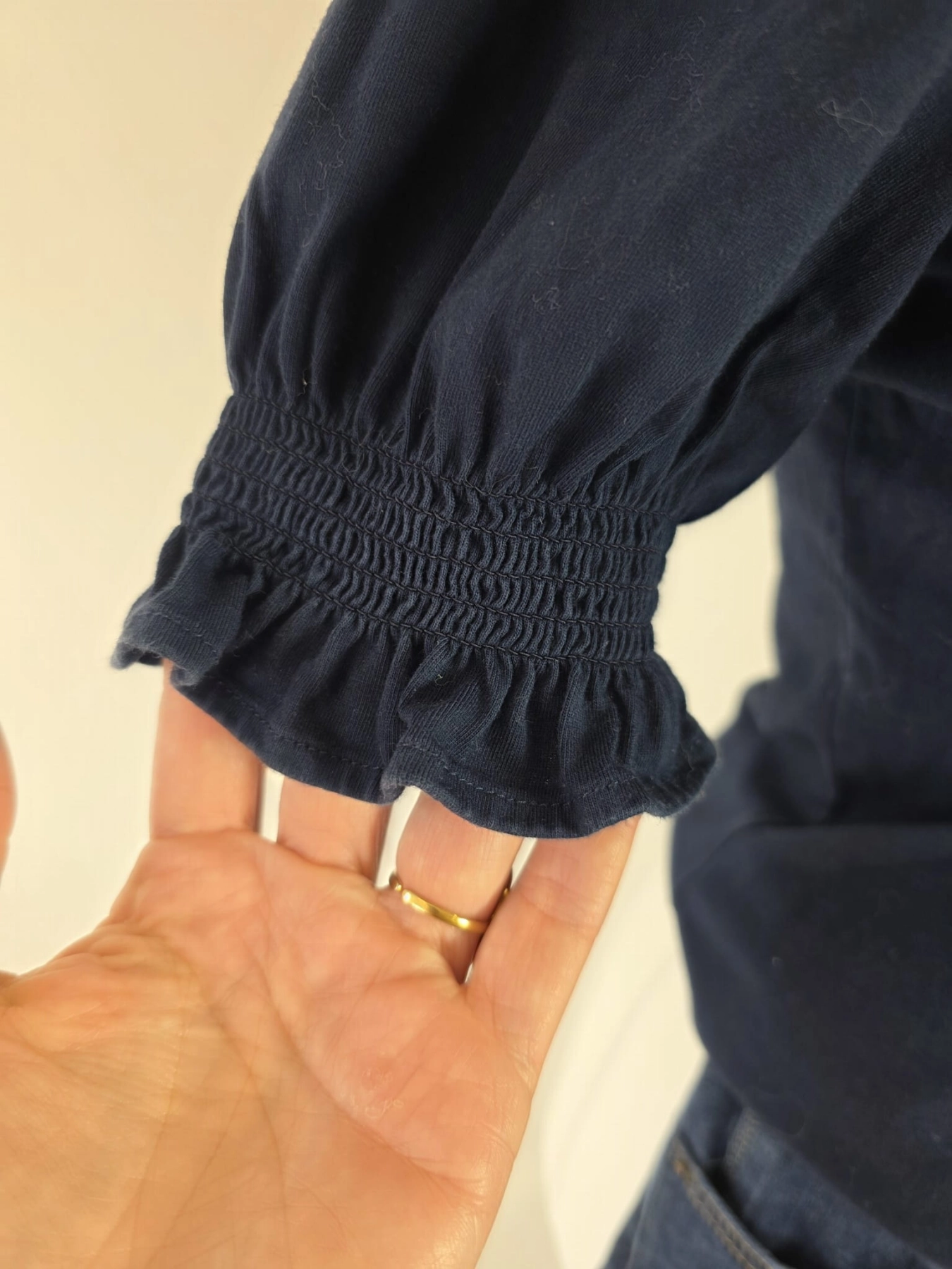 Damski komplet ze stylizacją premium: beżowa katana mbyM, granatowa bluzka Mellowfield oraz jeansy z wysokim stanem Levi's 721 High Rise Skinny