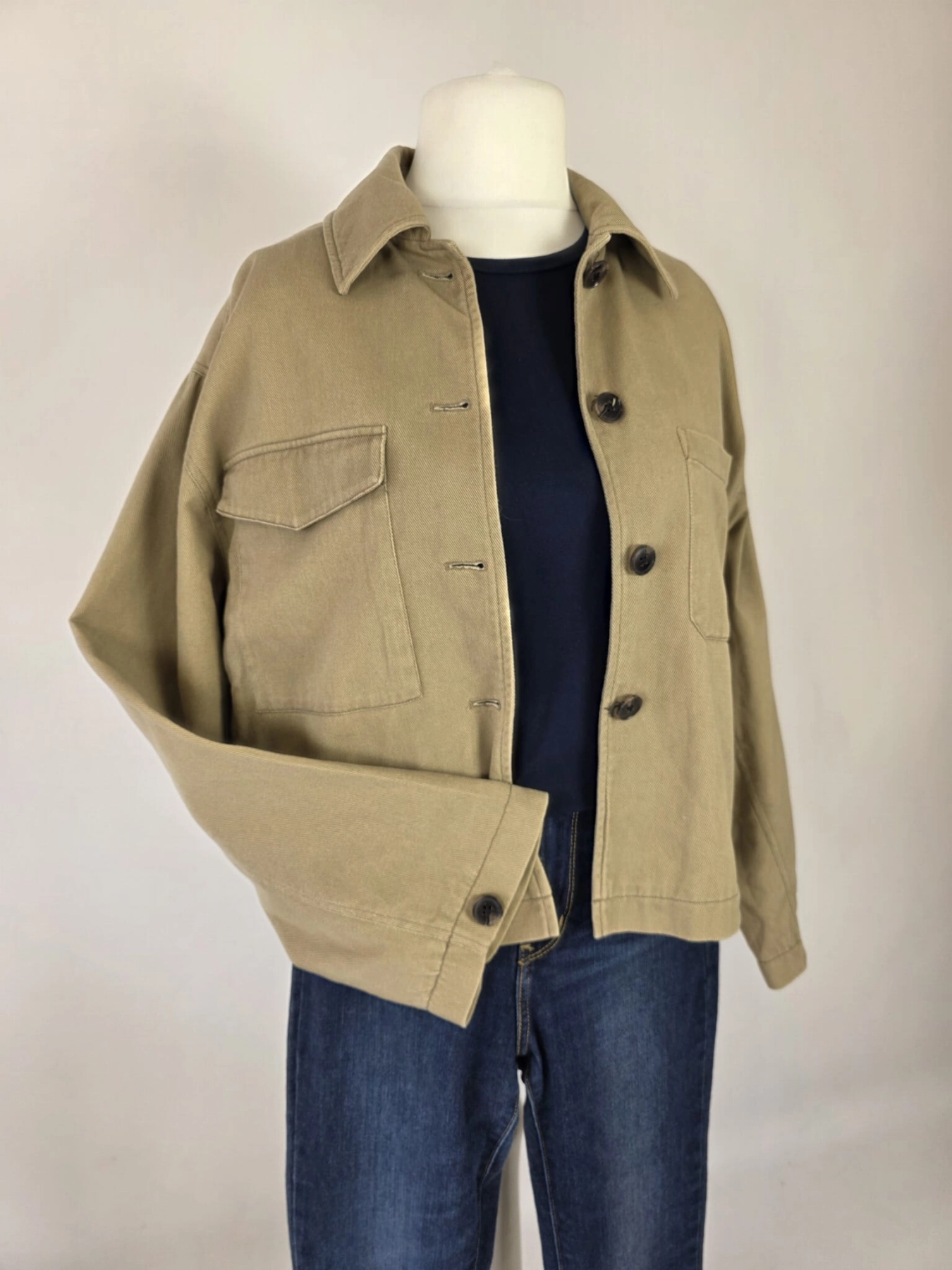 Damski komplet ze stylizacją premium: beżowa katana mbyM, granatowa bluzka Mellowfield oraz jeansy z wysokim stanem Levi's 721 High Rise Skinny