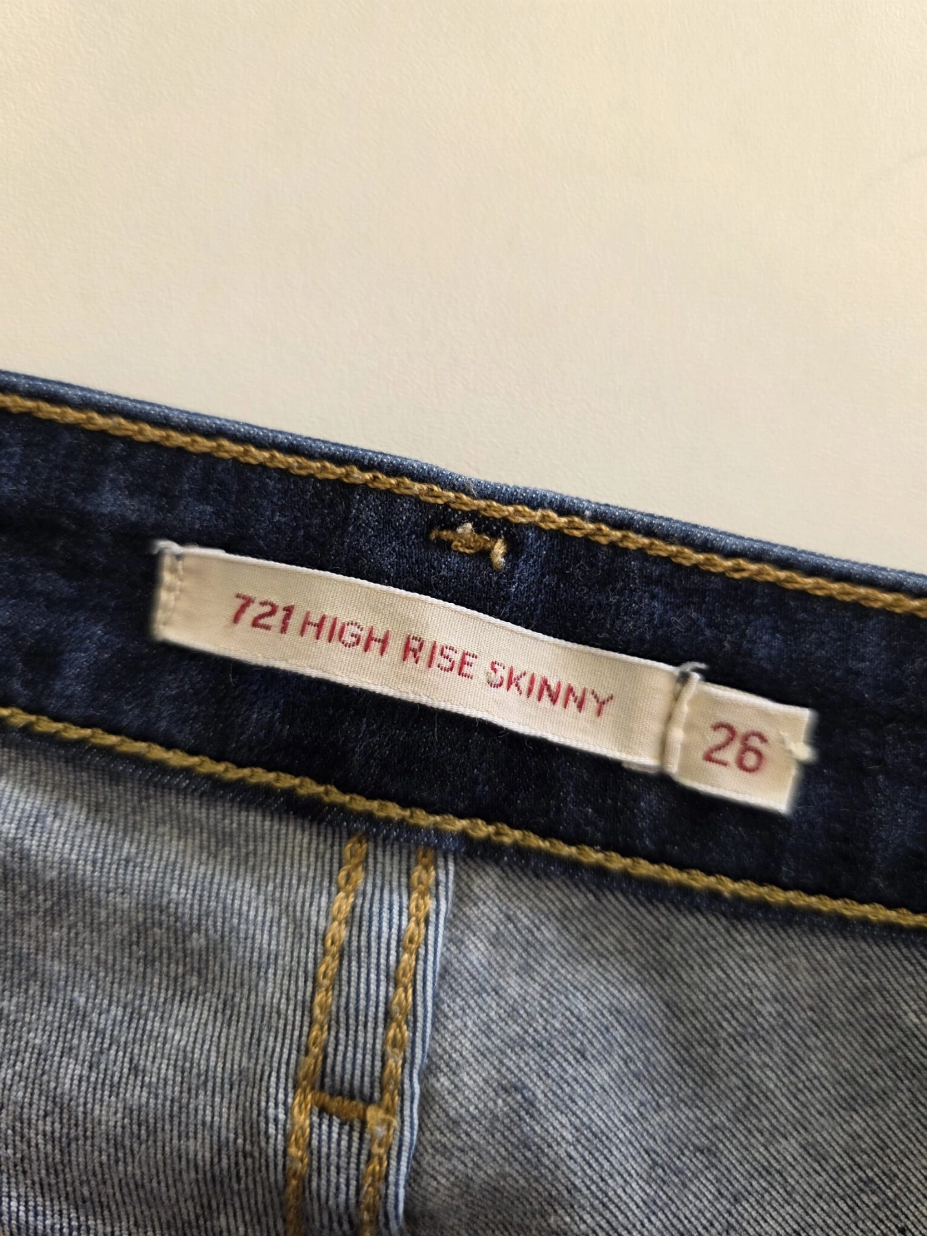 Damski komplet ze stylizacją premium: beżowa katana mbyM, granatowa bluzka Mellowfield oraz jeansy z wysokim stanem Levi's 721 High Rise Skinny