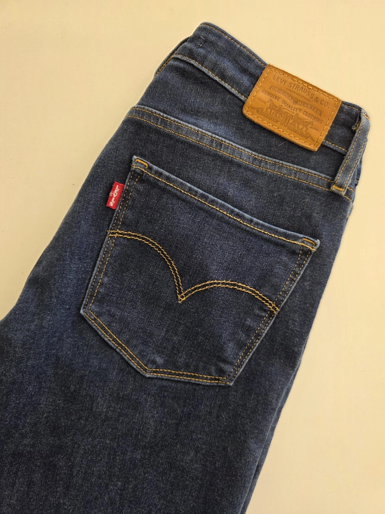 Damski komplet ze stylizacją premium: beżowa katana mbyM, granatowa bluzka Mellowfield oraz jeansy z wysokim stanem Levi's 721 High Rise Skinny