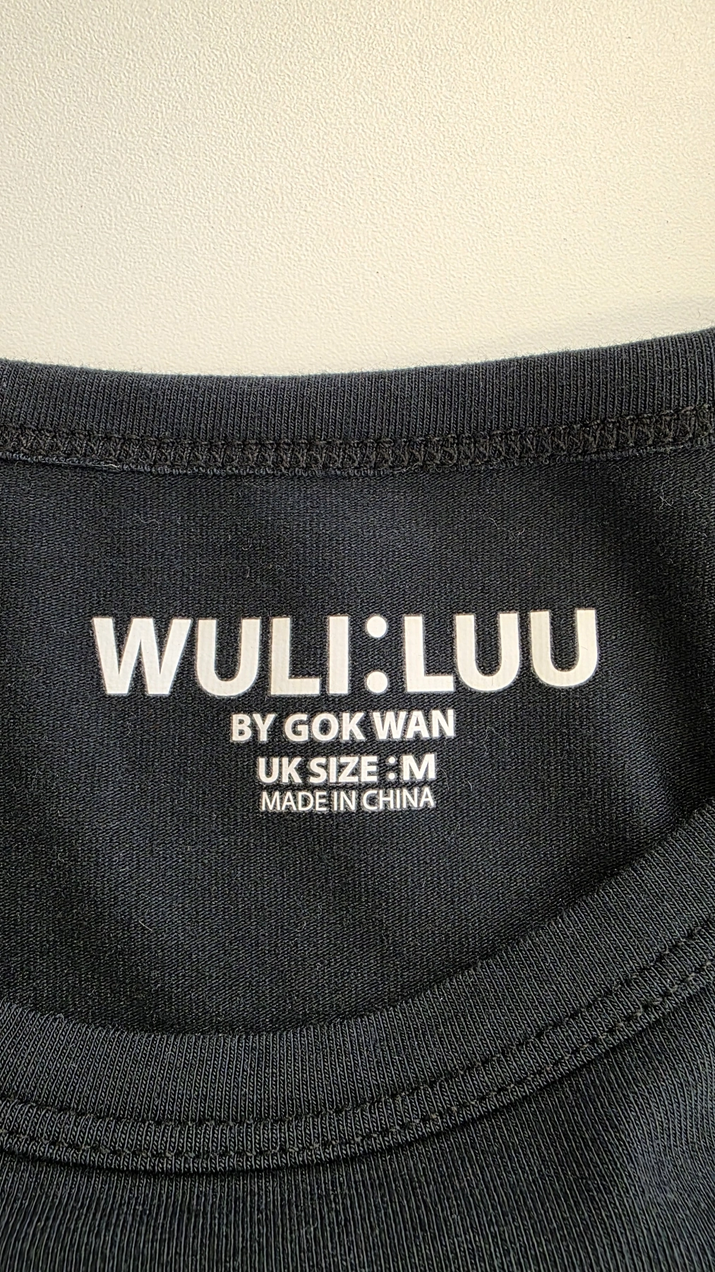 Trzyczęściowa stylizacja damska premium z czerwoną marynarką Kiabi, czarnym t-shirtem Wuli:Luu i eleganckimi spodniami w prążki