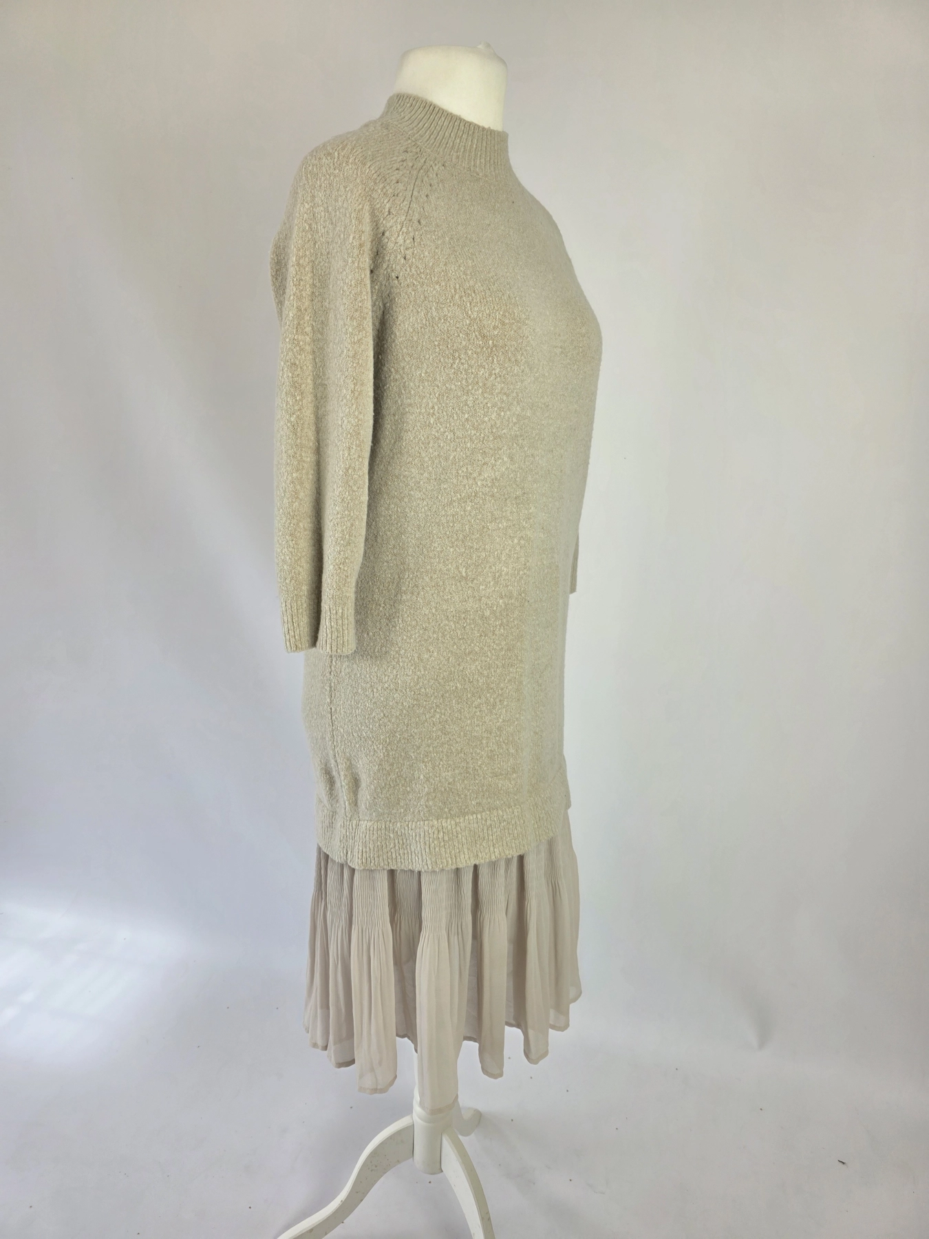 Kobieca, beżowa sukienka dzianinowa marki Reserved z plisowanym, zwiewnym dołem doskonale łączy komfort z eleganckim, nowoczesnym stylem