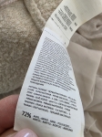 Kobieca, beżowa sukienka dzianinowa marki Reserved z plisowanym, zwiewnym dołem doskonale łączy komfort z eleganckim, nowoczesnym stylem