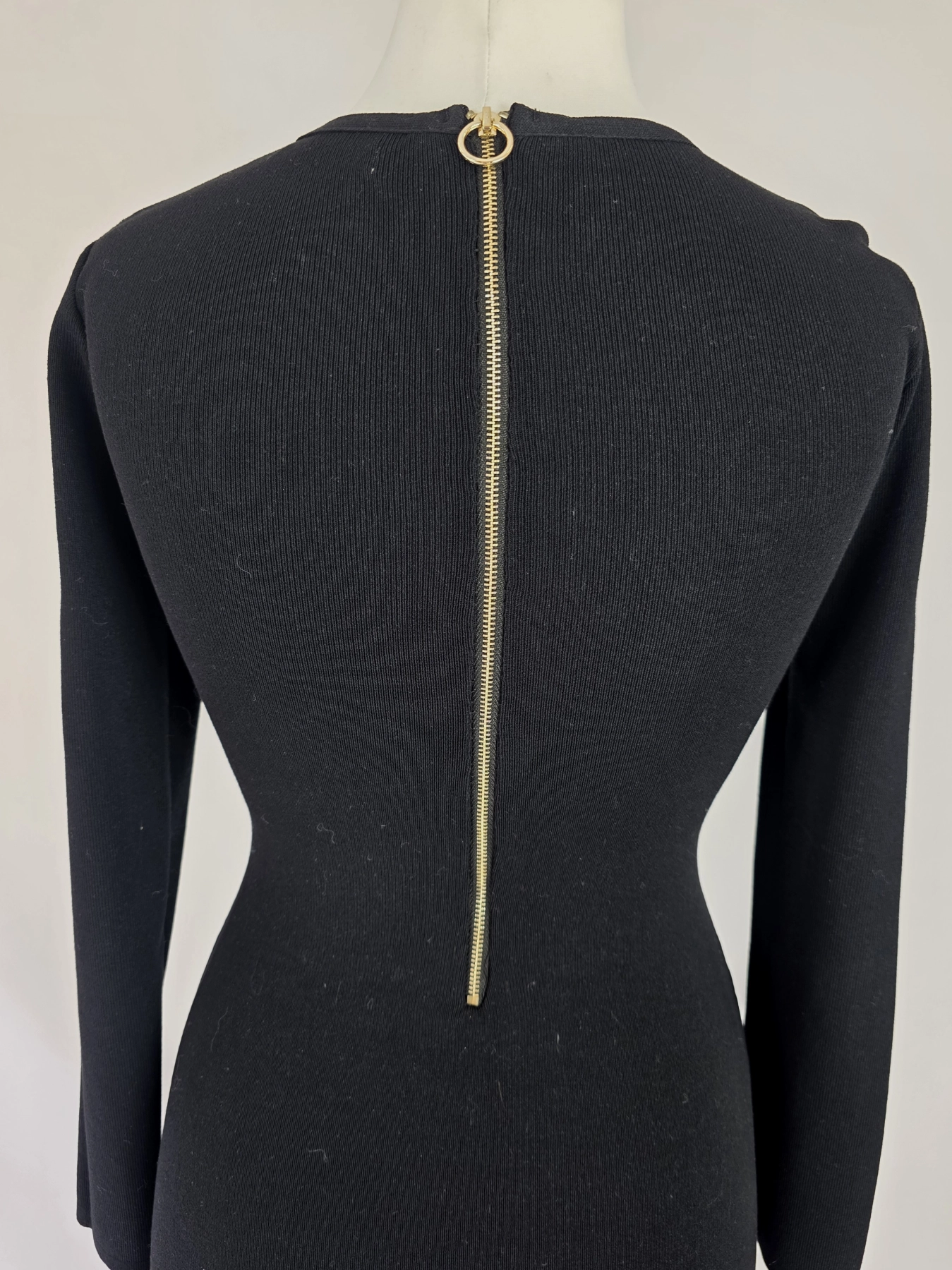 Elegancka czarna sukienka dresowa Allyson Collection ze złotymi guzikami i dżetami doskonale podkreśla kobiecą sylwetkę, łącząc styl militarny z wyjątkową wygodą