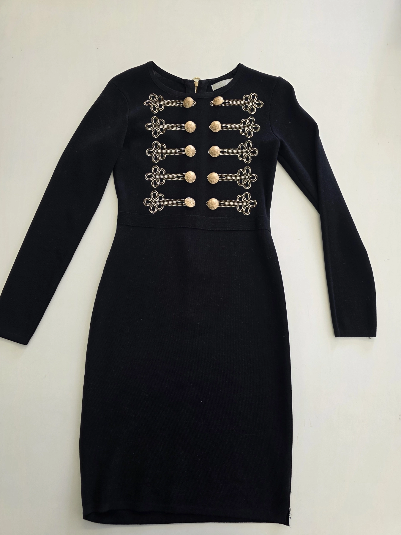 Elegancka czarna sukienka dresowa Allyson Collection ze złotymi guzikami i dżetami doskonale podkreśla kobiecą sylwetkę, łącząc styl militarny z wyjątkową wygodą