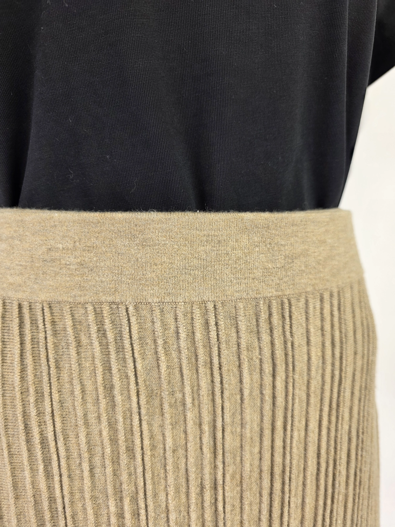 Elegancki zestaw kobiecy premium z czarną bluzką Simple, wełnianą prążkowaną spódnicą midi Claudia Sträter oraz dzianinowym ponczo w paski, idealny na chłodniejsze dni