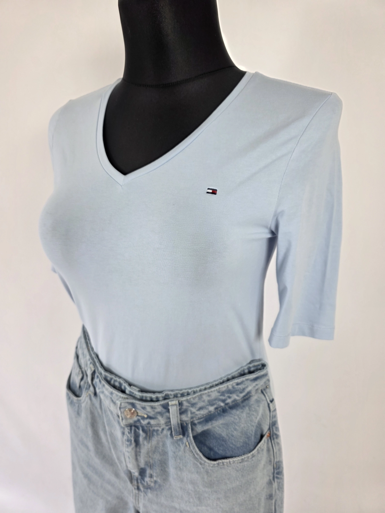 Kompletna damska stylizacja premium składająca się z marynarki w kratkę, t-shirtu Tommy Hilfiger z dekoltem V oraz jeansów Zara z wysokim stanem