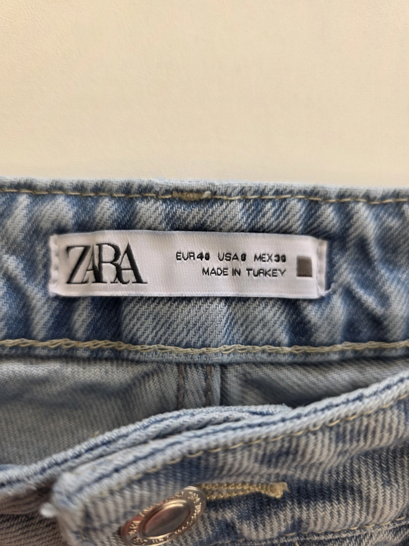 Kompletna damska stylizacja premium składająca się z marynarki w kratkę, t-shirtu Tommy Hilfiger z dekoltem V oraz jeansów Zara z wysokim stanem