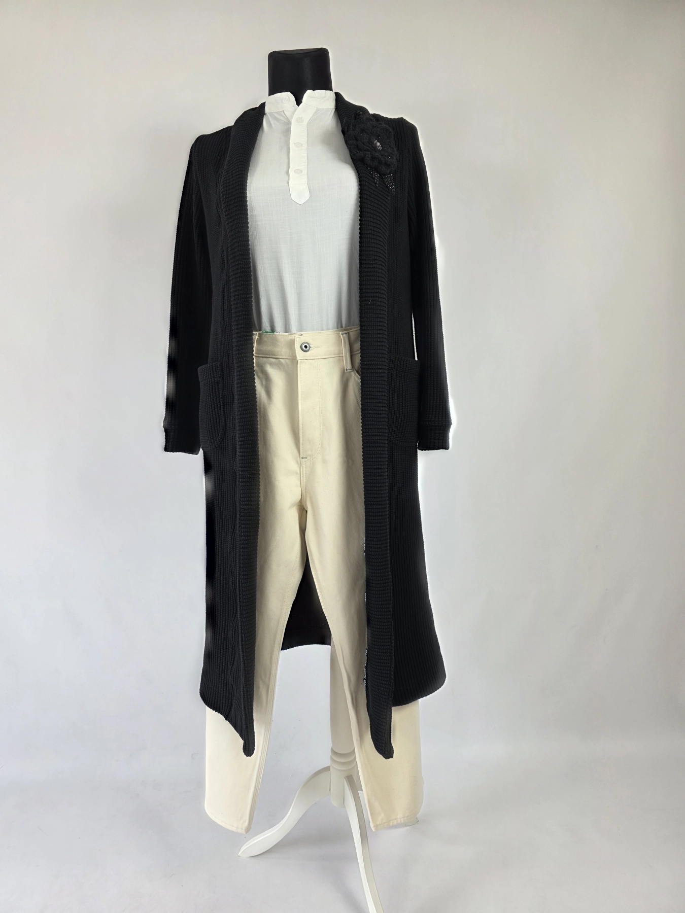 Stylowy komplet damski skomponowany przez stylistkę, składający się z długiego kardiganu Niumi, białej bluzki oraz jasnych spodni G-Star RAW z broszką
