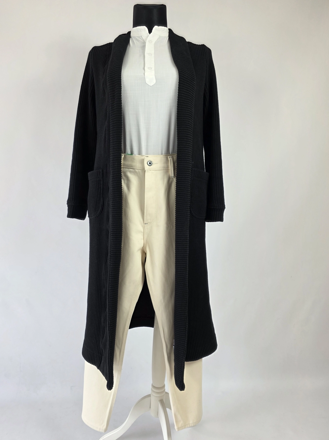 Stylowy komplet damski skomponowany przez stylistkę, składający się z długiego kardiganu Niumi, białej bluzki oraz jasnych spodni G-Star RAW z broszką