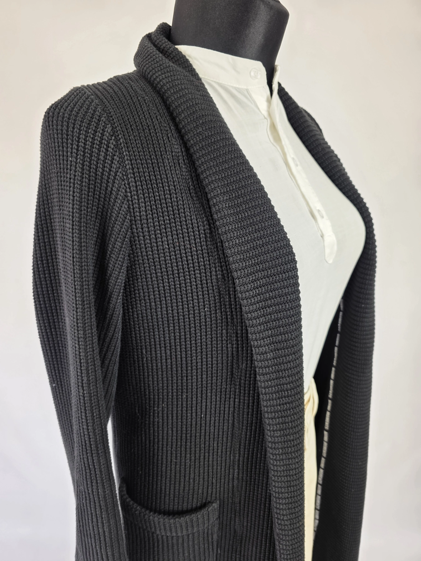 Stylowy komplet damski skomponowany przez stylistkę, składający się z długiego kardiganu Niumi, białej bluzki oraz jasnych spodni G-Star RAW z broszką