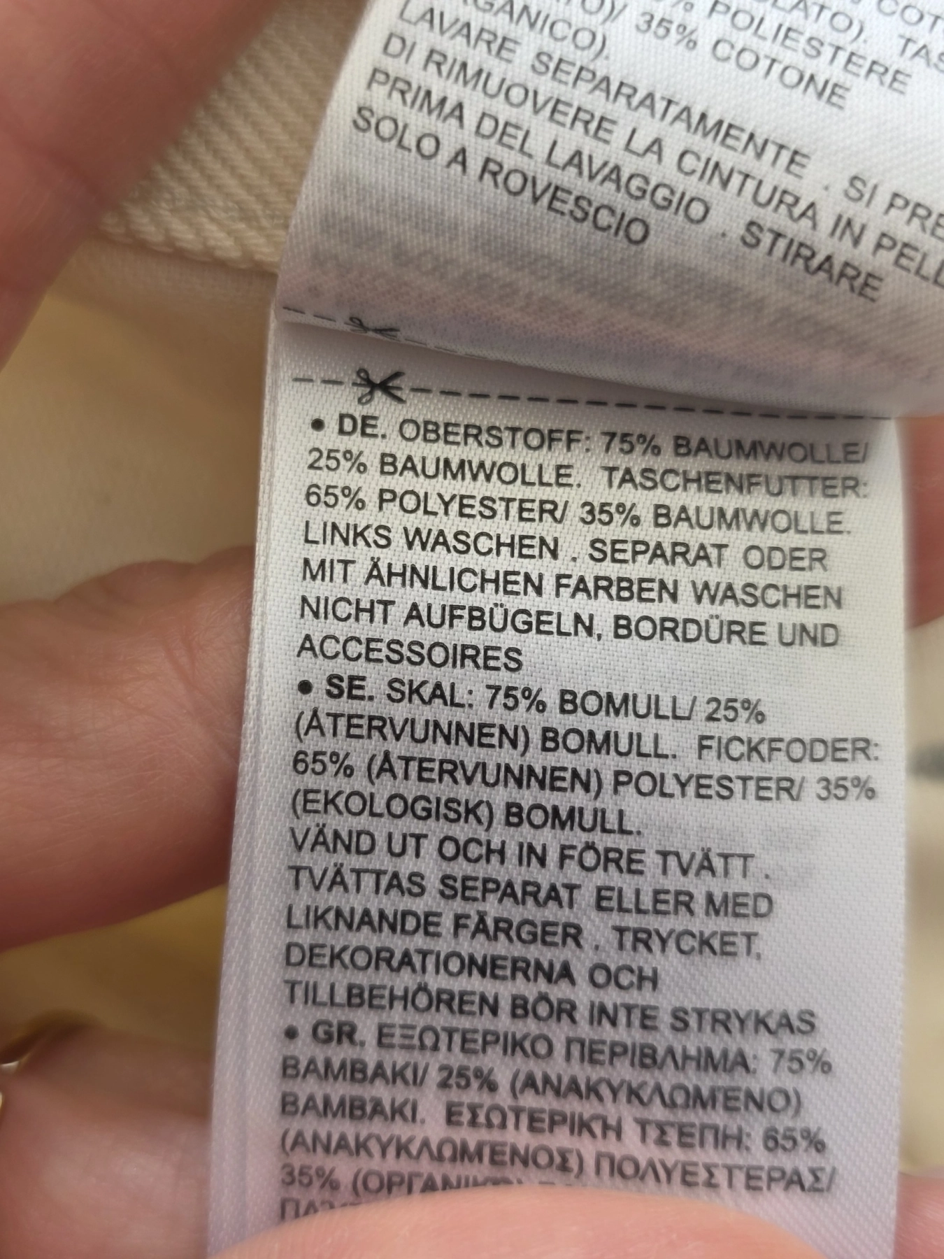 Stylowy komplet damski skomponowany przez stylistkę, składający się z długiego kardiganu Niumi, białej bluzki oraz jasnych spodni G-Star RAW z broszką