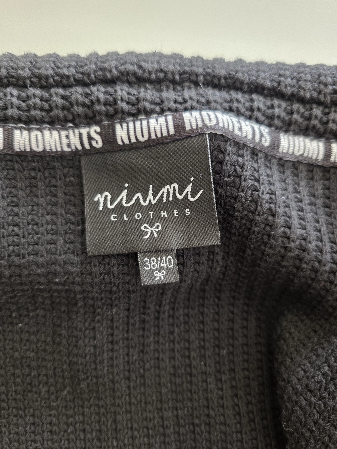 Stylowy komplet damski skomponowany przez stylistkę, składający się z długiego kardiganu Niumi, białej bluzki oraz jasnych spodni G-Star RAW z broszką