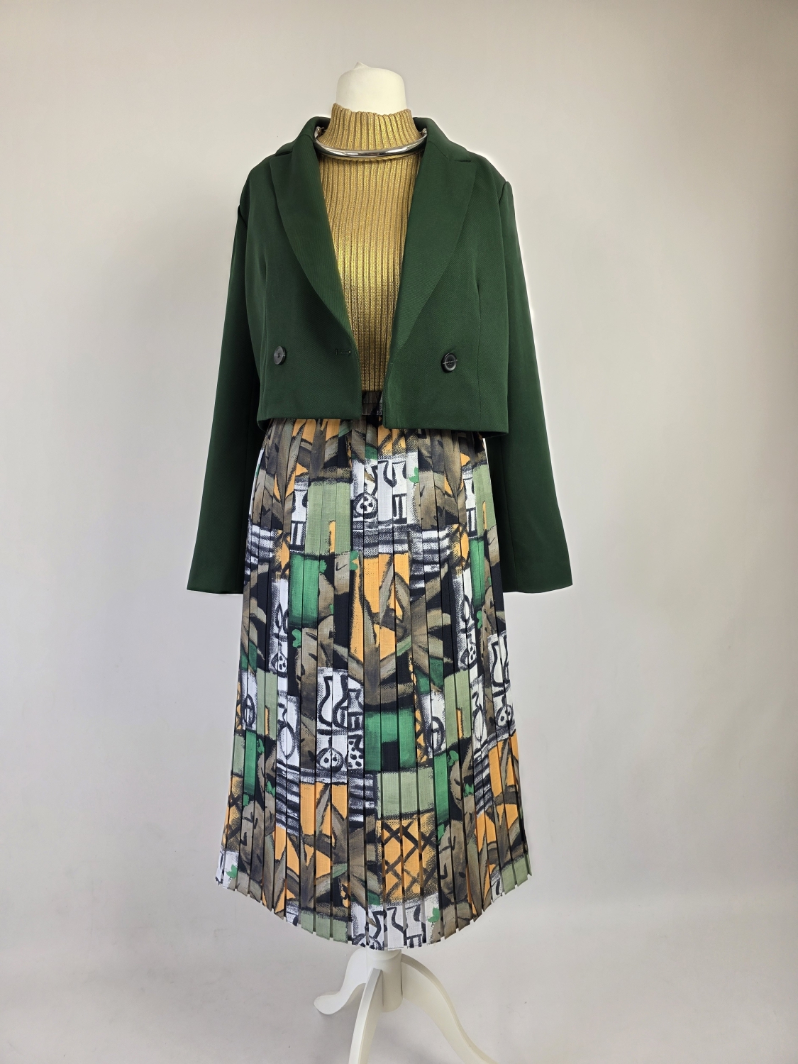 Skomponowany przez naszą stylistkę zestaw ze spódnicą midi Lotos, zielonym żakietem ONLY oraz złotym półgolfem Lindex to wyrazista stylizacja vintage premium ze srebrnym naszyjnikiem w komplecie