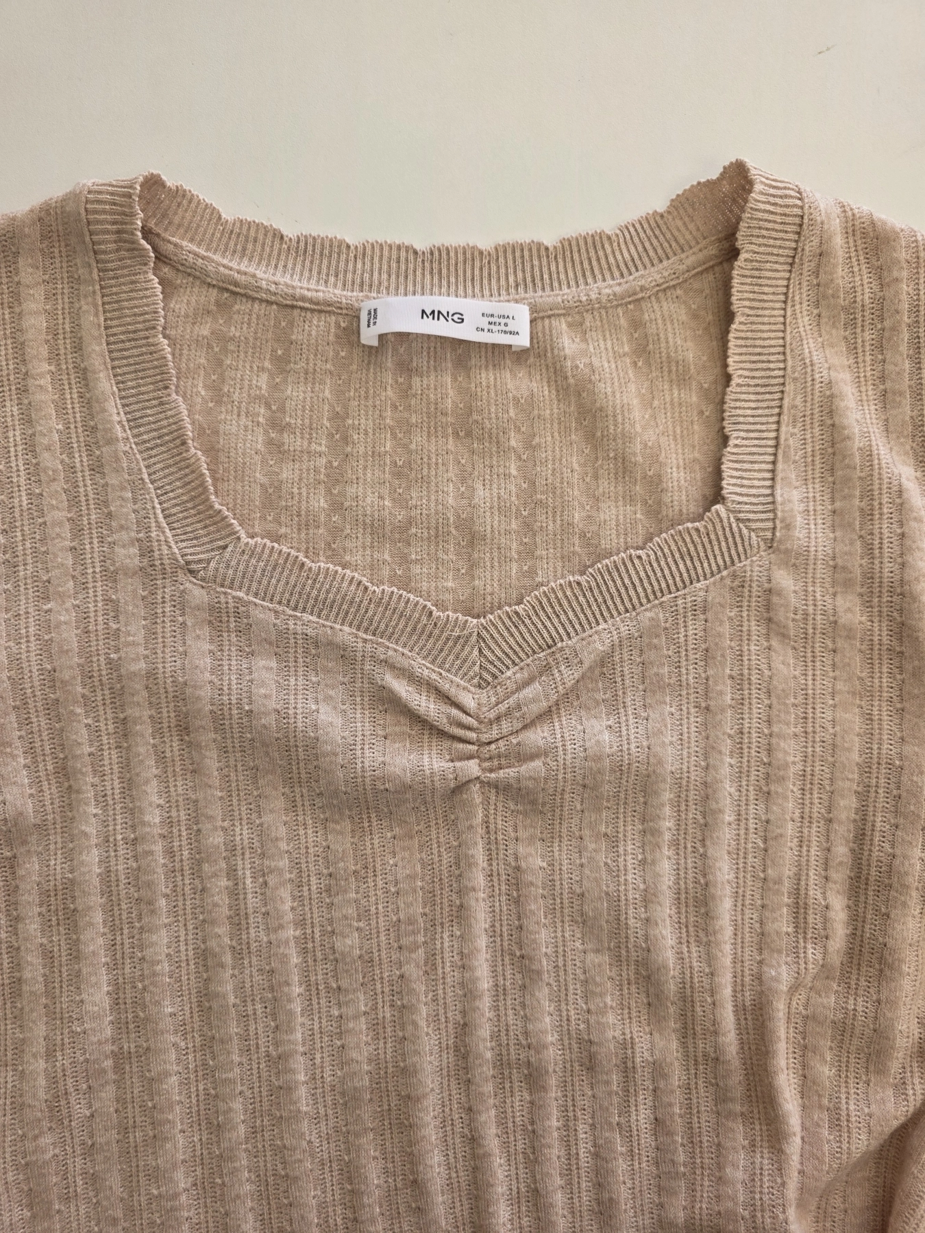 Kobieca stylizacja premium łącząca czarną marynarkę Bershka, beżową bluzkę MNG oraz wzorzyste spodnie z wysokim stanem